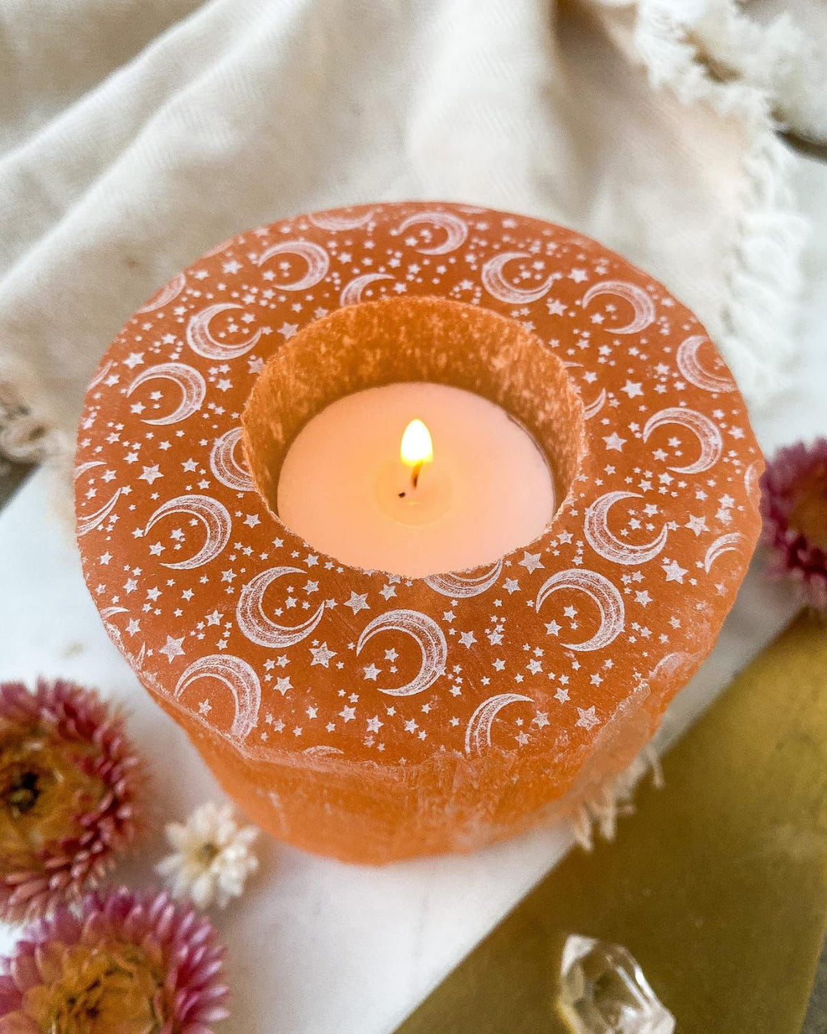 Bougeoir orange en sélenite lune et étoiles gravées avec bougie allumée Pure Selenite